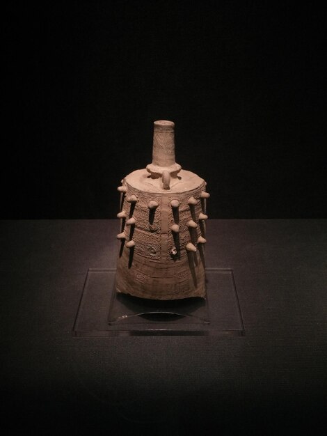 A detailed digital 3D model of an ancient ceremonial pipe, rendered with realistic textures and shadows, displayed on a large monitor in a research lab.