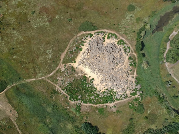 Aerial view of Monks Mound at Cahokia Mounds State Historic Site, showing its massive size and the surrounding flat floodplain, with a few trees on the mound itself.