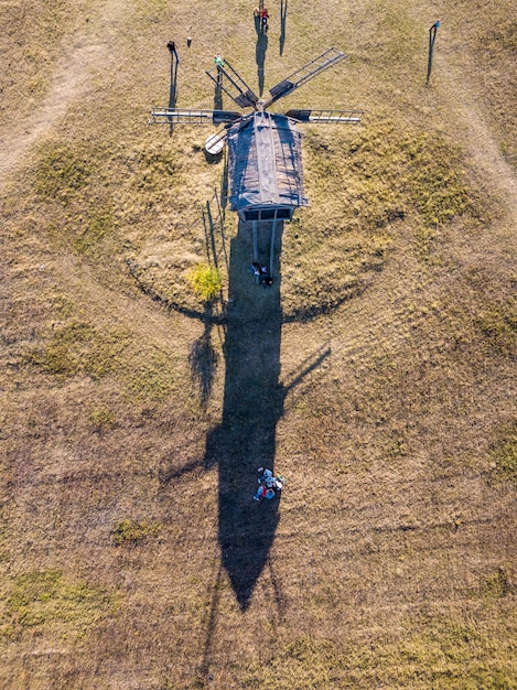 A drone flying over a large forested area, equipped with lidar technology, capturing topographical data. In the background, a research team uses ground-penetrating radar.