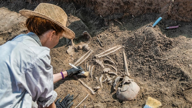 An archaeologist carefully excavating a site in Jamestown, Virginia. The archaeologist is using small tools to uncover artifacts, illustrating the meticulous work required in archaeological research. The scene shows the importance of proper excavation techniques for Preserving America's Archaeological Heritage: The Role of Federal Laws and Regulations.