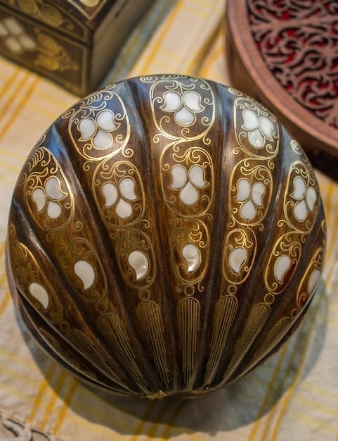 A close-up photo of a collection of intricately carved shell ornaments discovered at an archaeological site in the Midwestern United States. The shells are displayed on a dark background, highlighting their delicate craftsmanship and the details of the carvings. The artifacts are representative of items traded along Ancient Trade Routes of North America: Evidence from Archaeological Discoveries Across the US.