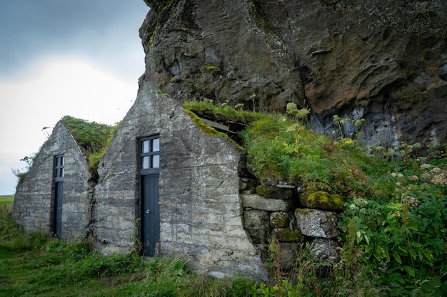 A photograph of Skara Brae in Scotland, showing the ancient stone houses situated close to the coastline. The sea is visible in the background, and there are signs of coastal erosion affecting the surrounding landscape. The image illustrates how The Impact of Climate Change on Archaeological Sites: Protecting Our Heritage from Erosion and Rising Sea Levels is endangering this Neolithic settlement.
